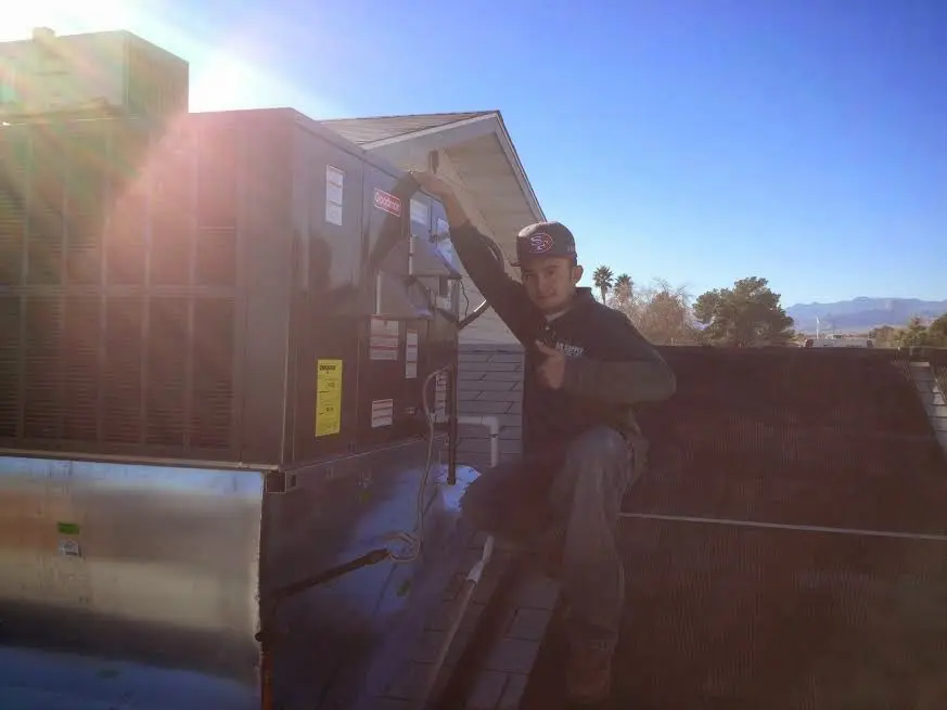 HVAC technician performing HVAC Inspection on a rooftop unit in Louisville